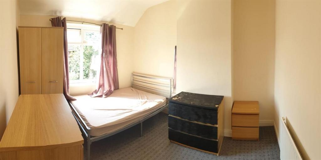 Bright, simply furnished bedroom with a double ...