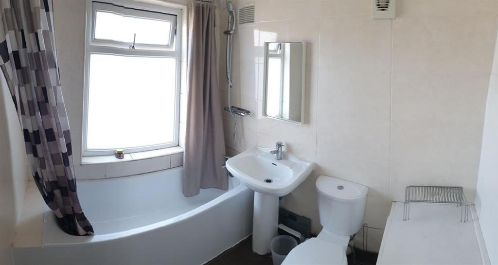 Bright, well-maintained bathroom with a curved ...