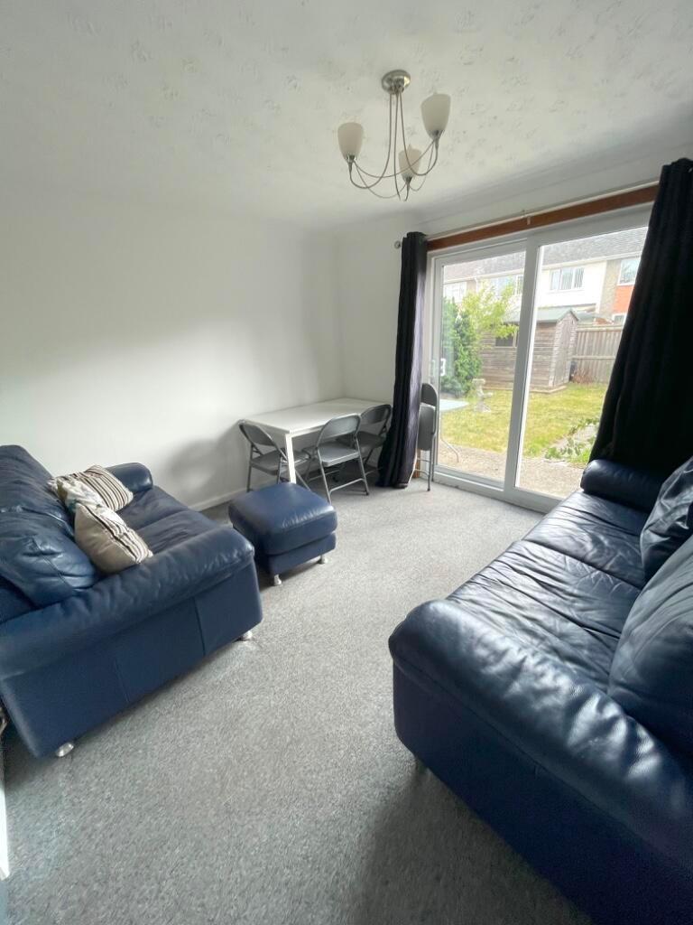 Bright living room with sliding glass doors ope...