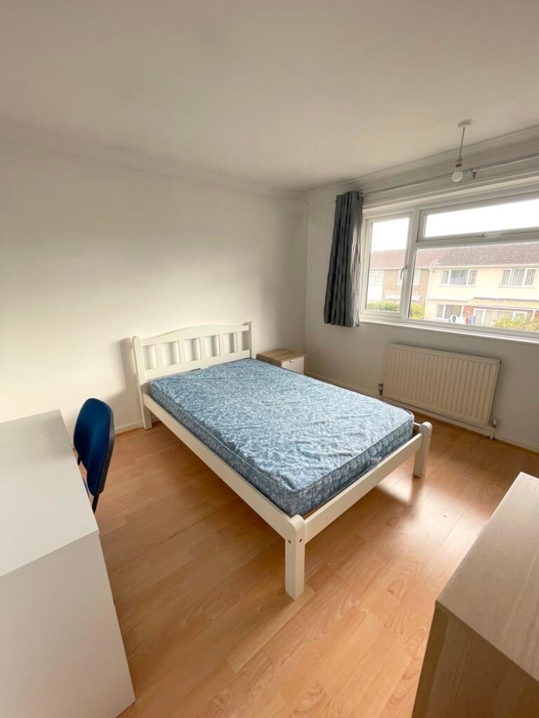 Bright, simply furnished bedroom with a white w...