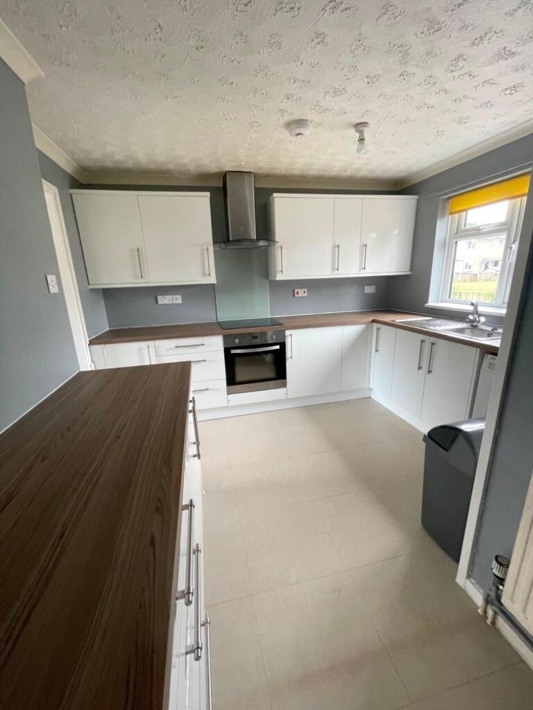 Bright modern kitchen with white gloss cabinets...