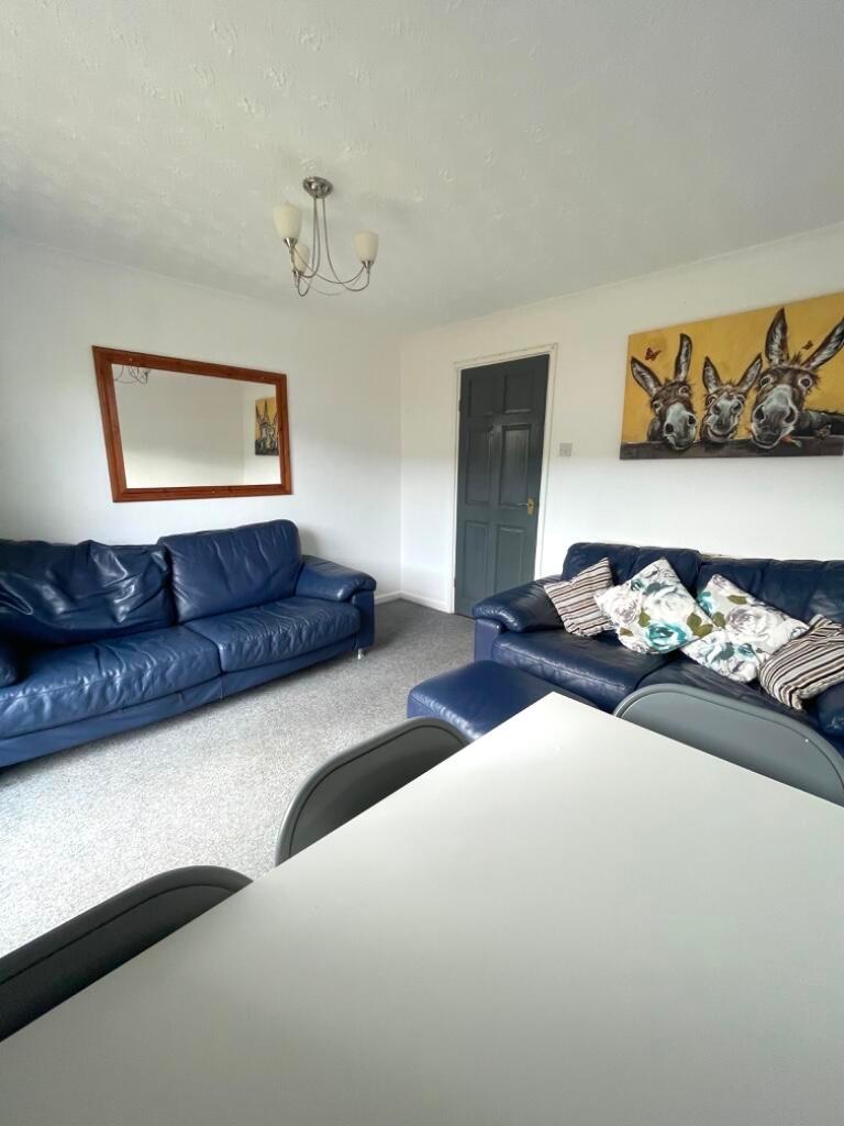 Bright, well-kept living room with two navy lea...