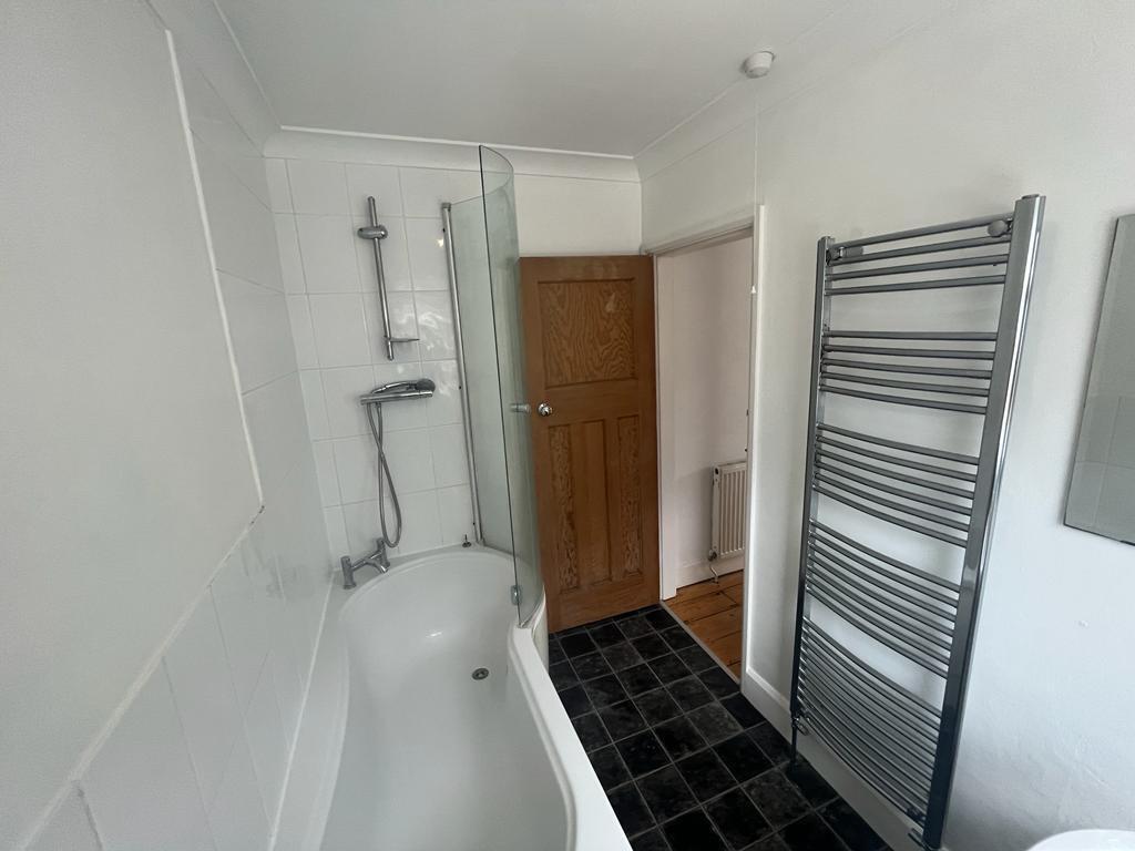 Bright, modern bathroom featuring a curved bath...