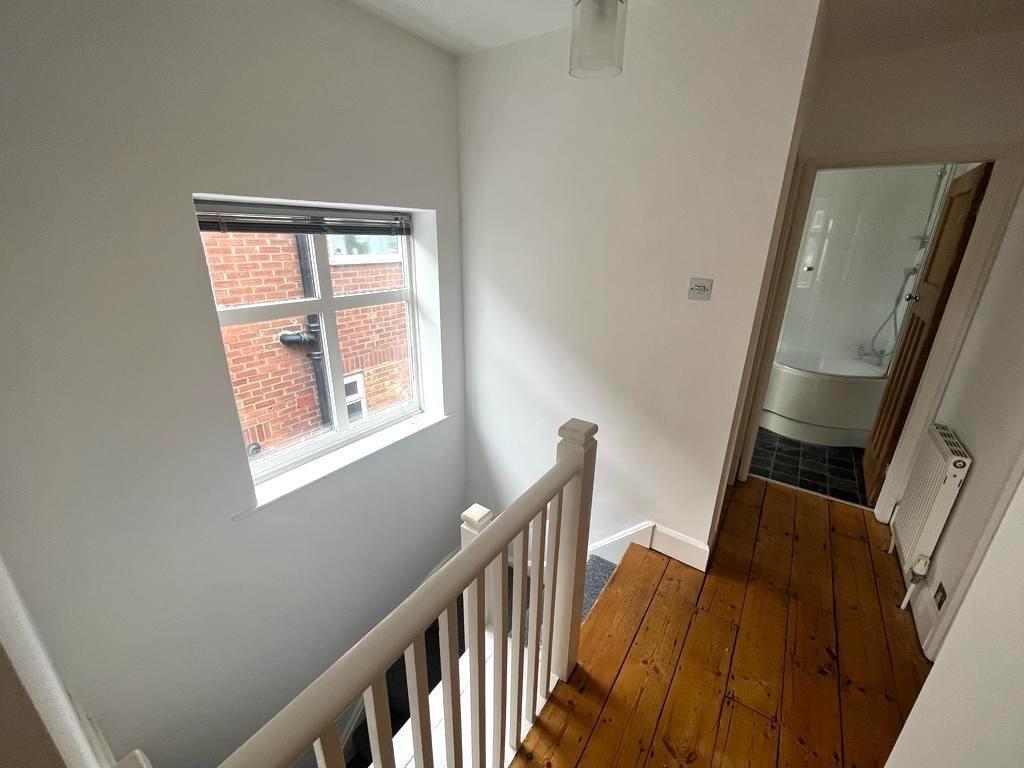 Bright, freshly painted landing with a large wi...
