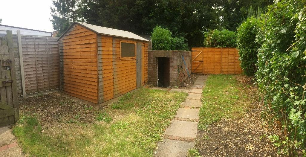 Private rear garden with a paved path, lawn are...