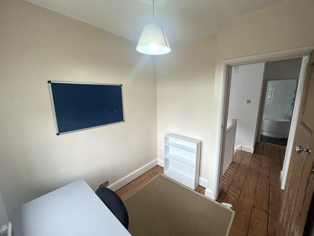 Bright, neutrally painted single bedroom with w...