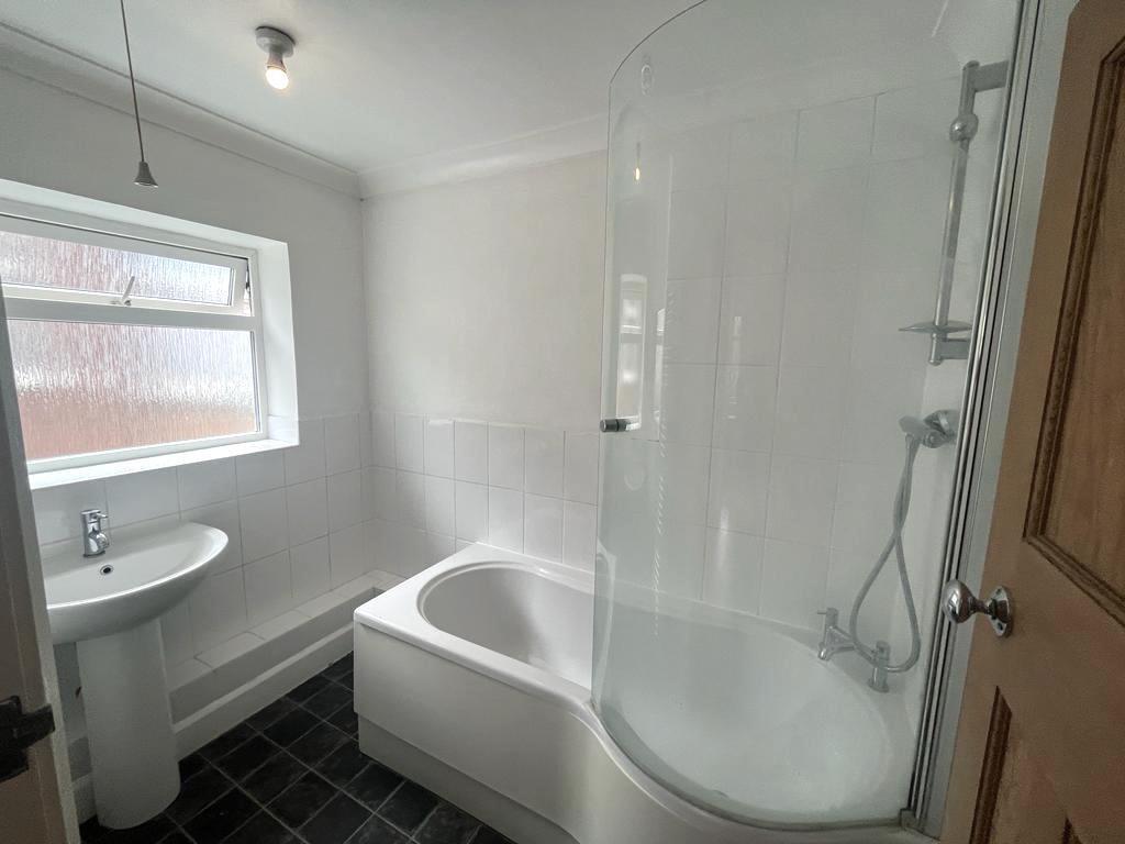 Bright, clean bathroom with a modern shower-ove...