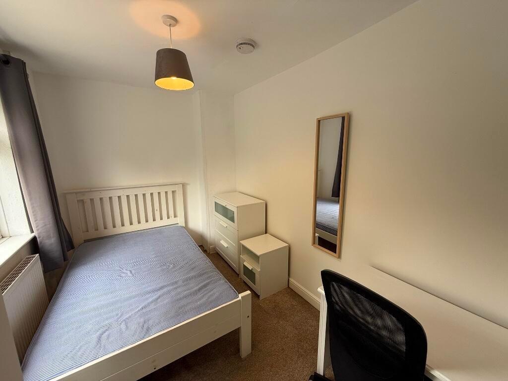 Bright, simply furnished bedroom with a double ...