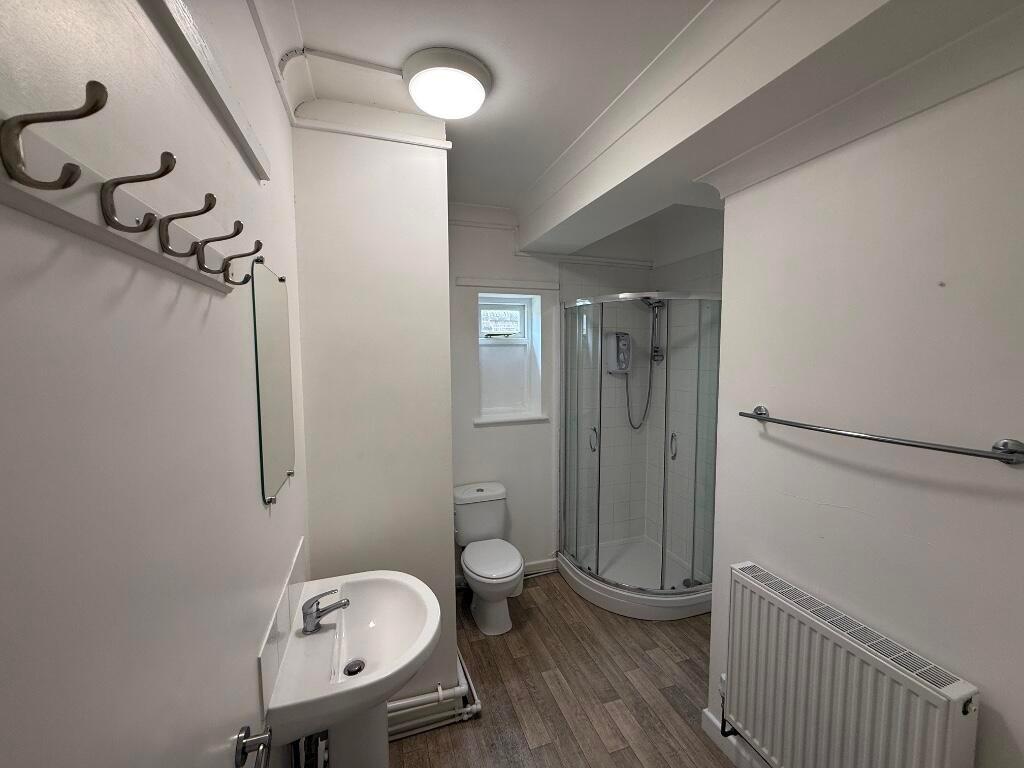 Bright, well-kept bathroom with a corner glass ...