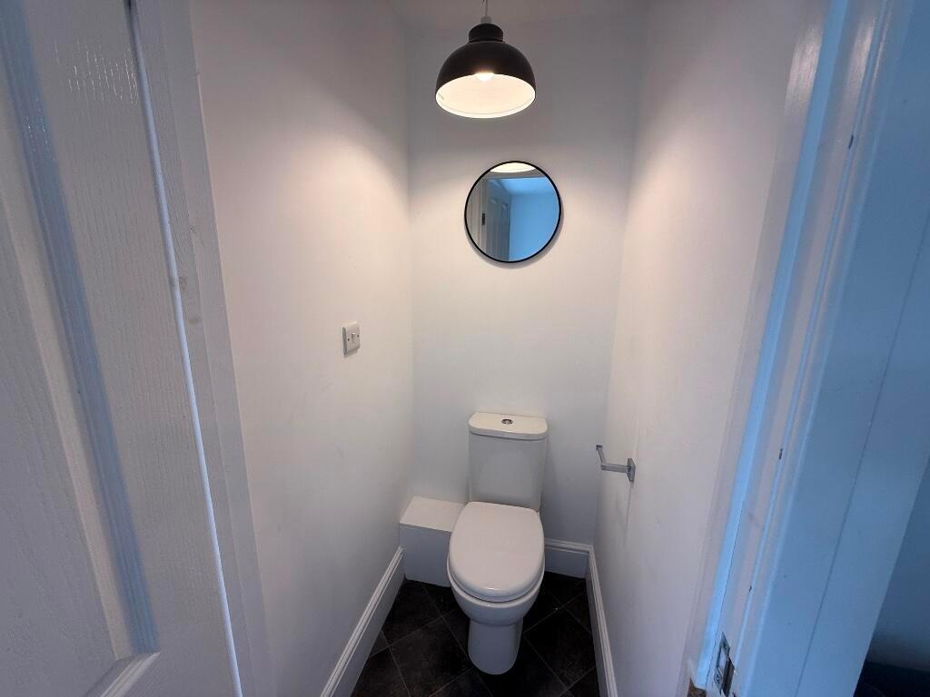 Neat, modern WC with white walls, a contemporar...