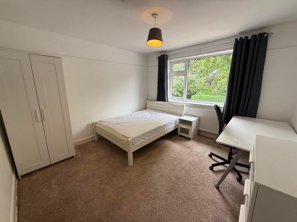 Bright, neutrally decorated double bedroom with...