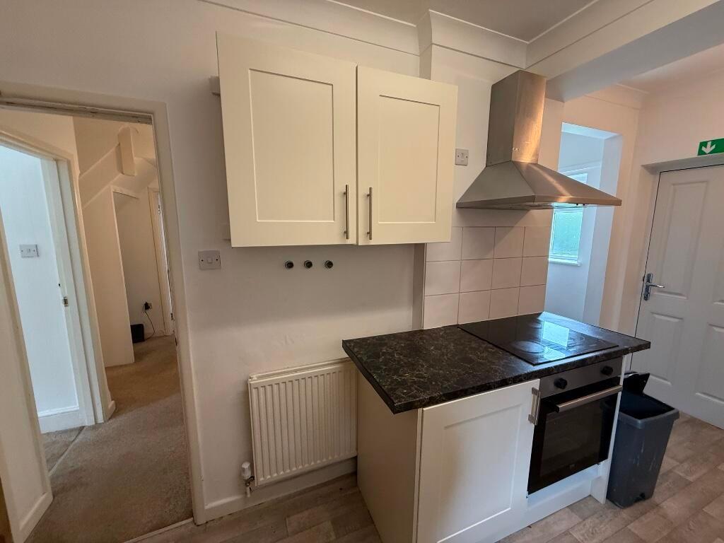 Compact fitted kitchen with a dark stone-effect...