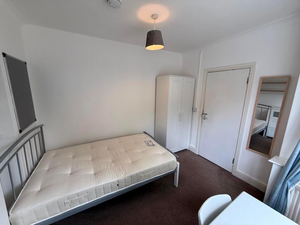 Bright, simply furnished bedroom with a comfort...