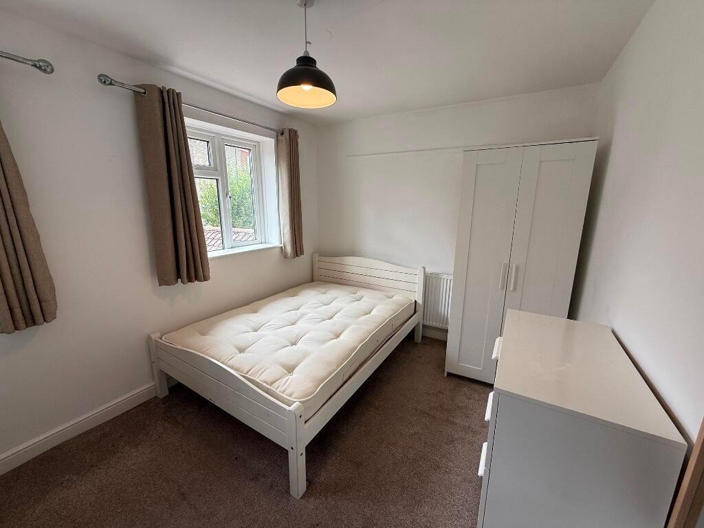 Bright, simply furnished bedroom with a comfort...