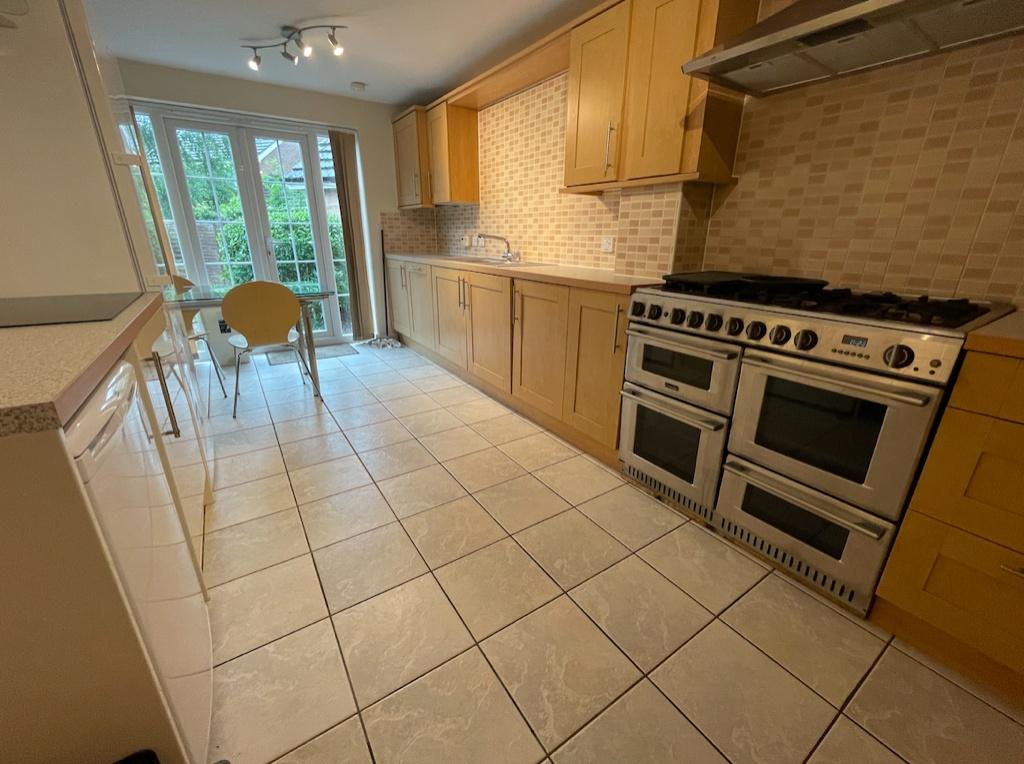 Bright galley-style kitchen with large stainles...
