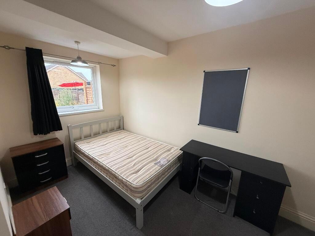 Bright, simply furnished bedroom with a double ...