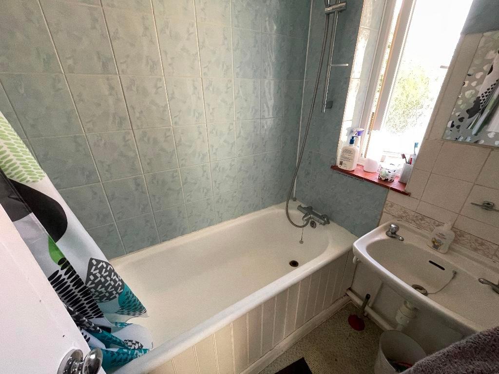 Compact, well-maintained bathroom with a full-s...