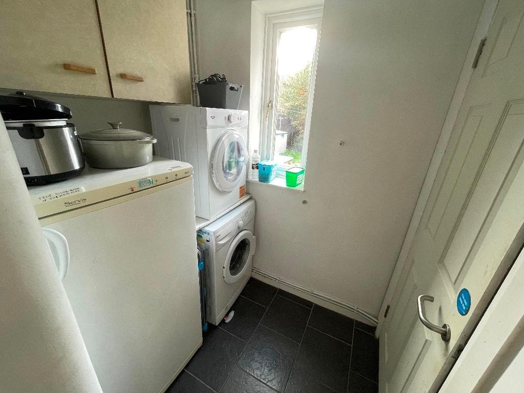 Compact utility room with stacked washer and dr...