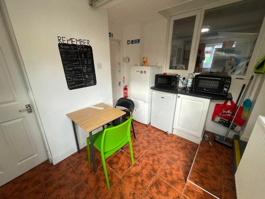 Compact shared kitchen with tiled floor, small ...