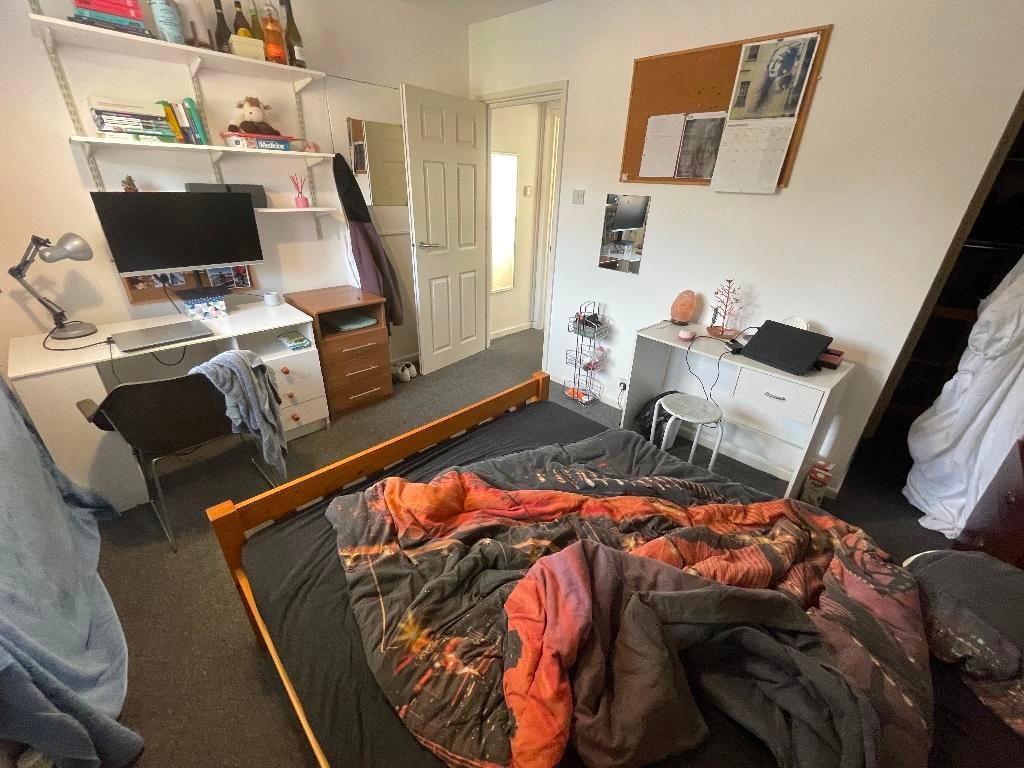 Cozy double bedroom with a wooden bed frame, be...