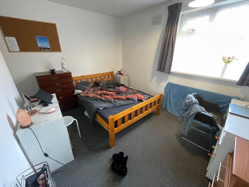 Bright double bedroom with a wooden bed frame, ...