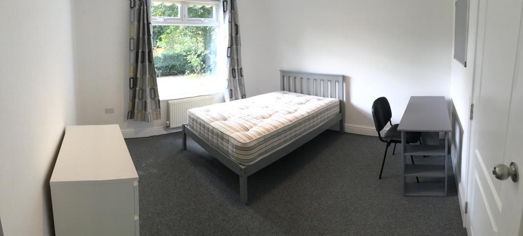 Bright, neutrally decorated bedroom with a doub...