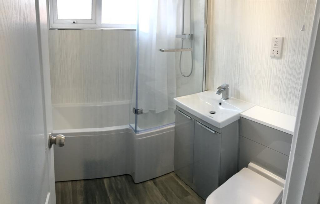 Bright modern bathroom with a combined shower-b...