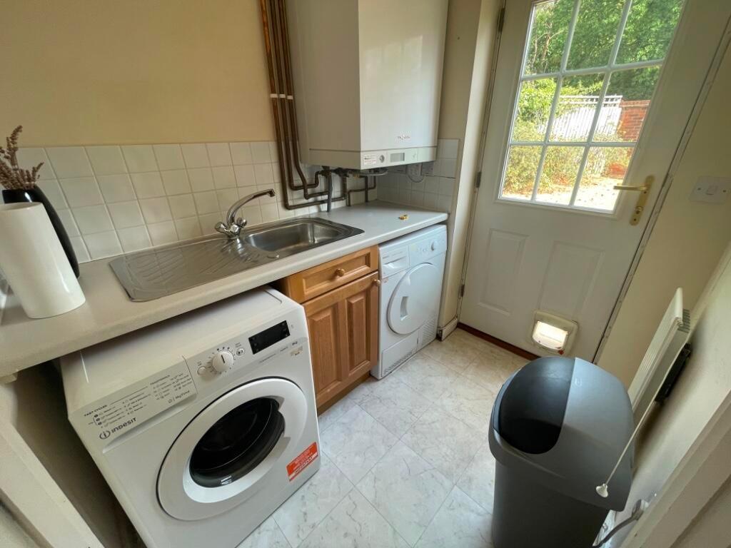 Bright utility room with sink, countertop and i...