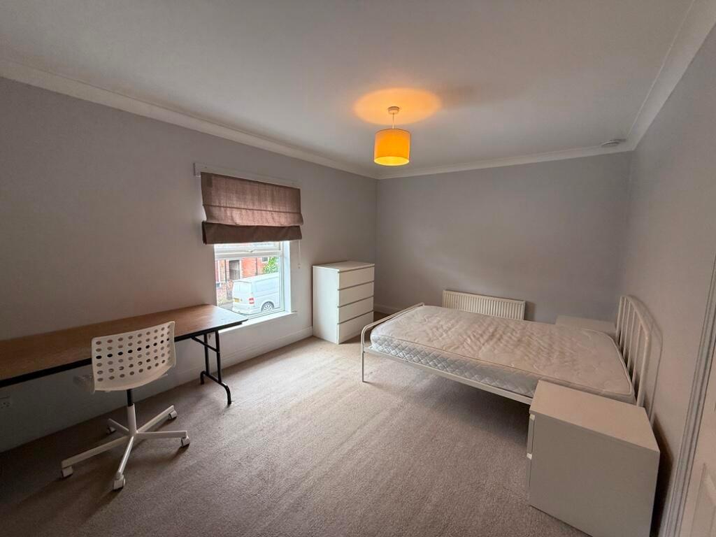 Bright, neutral double bedroom with a double be...