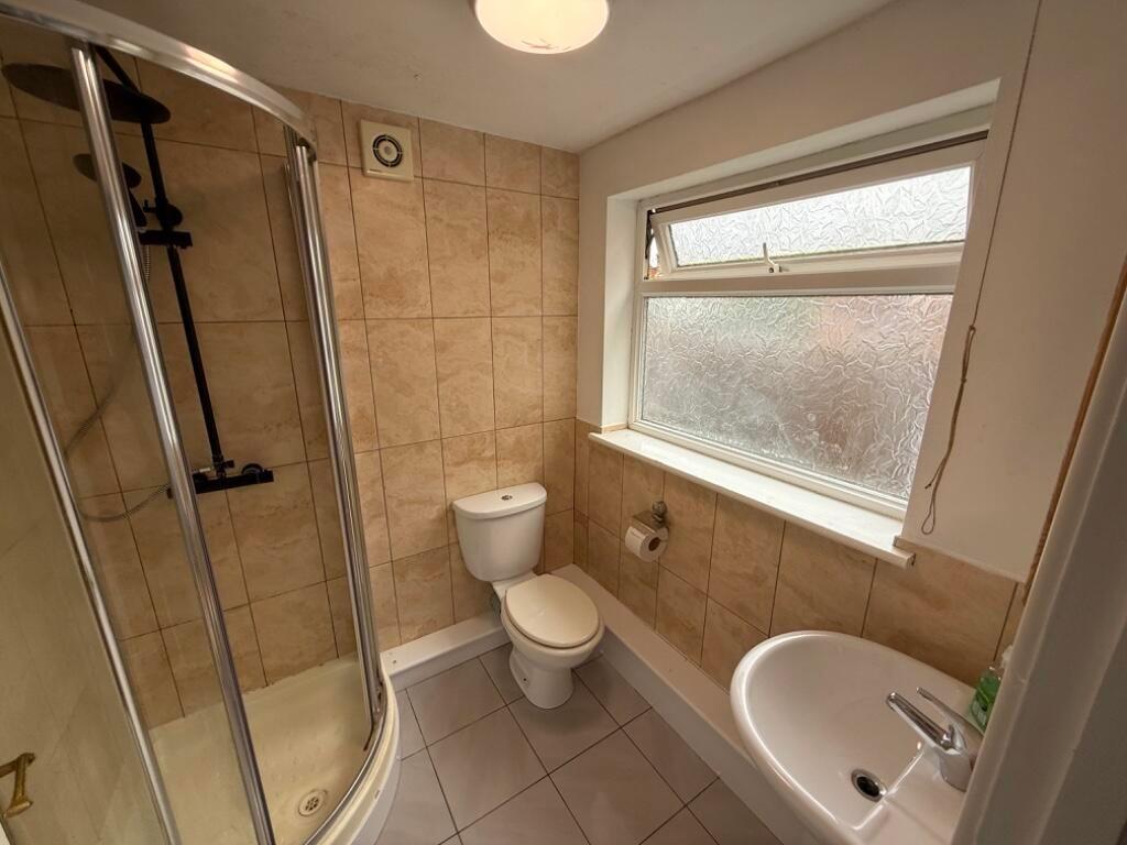 Well-maintained bathroom with a corner shower e...