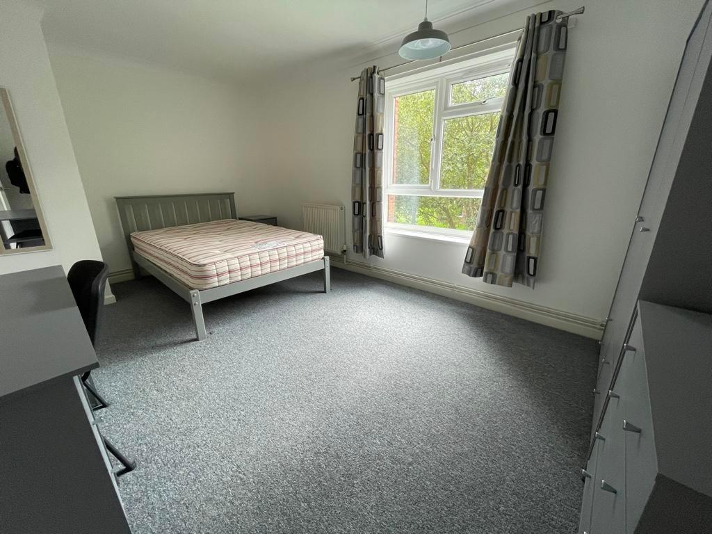 Bright double bedroom with a large window offer...