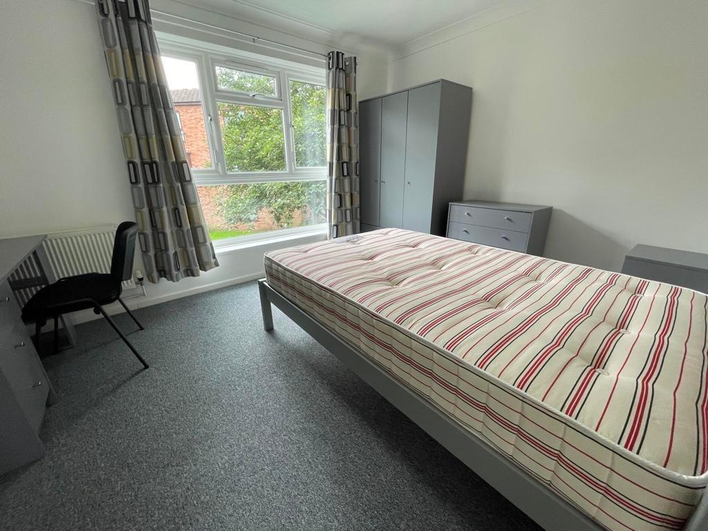 Bright, neatly presented bedroom with a large w...