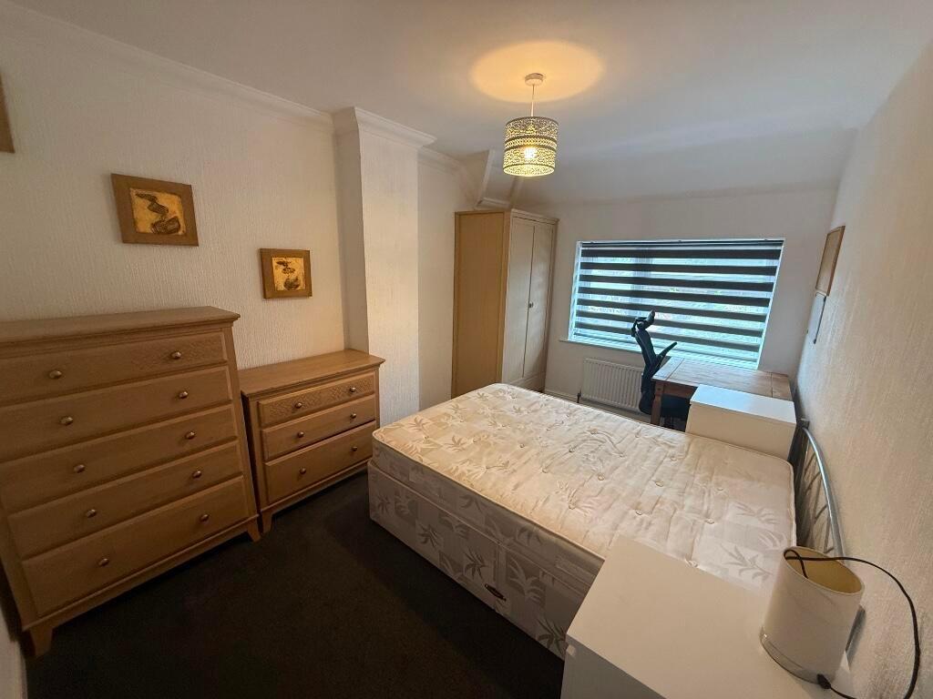 Bright, neatly furnished double bedroom with a ...