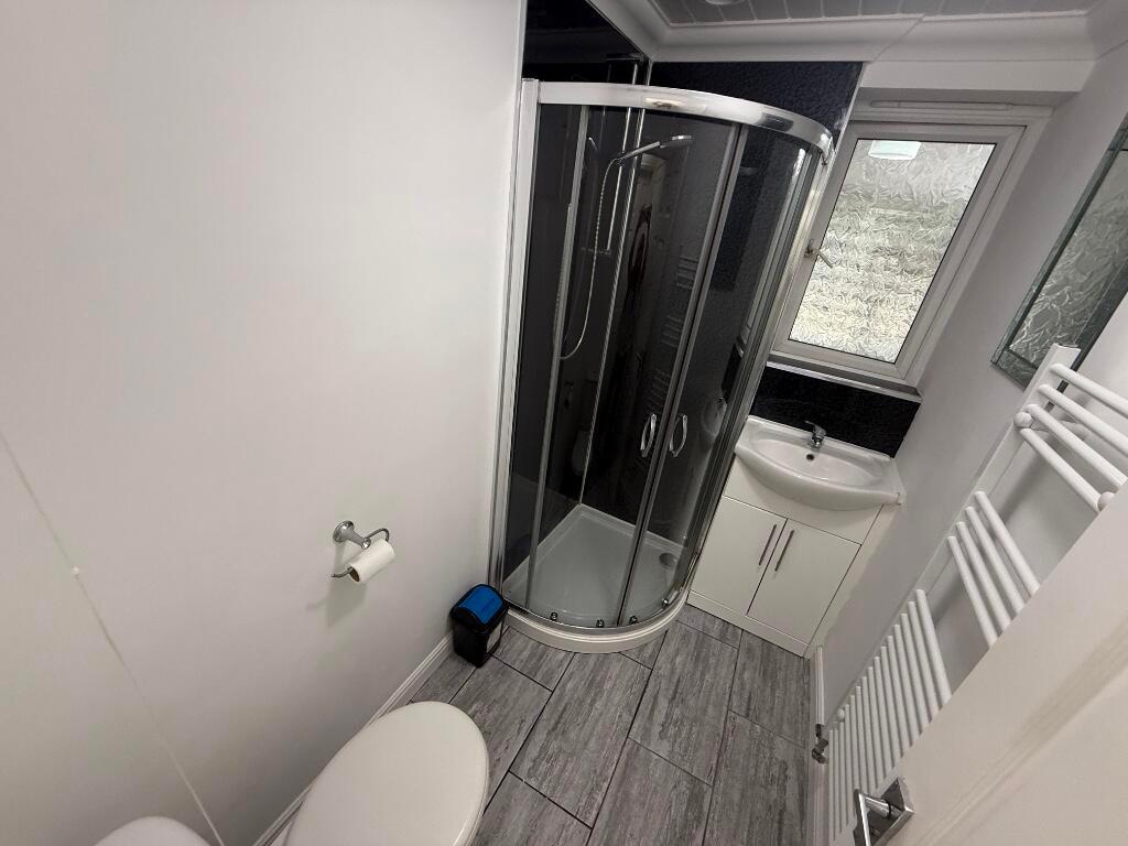 Modern, well-maintained bathroom with a curved ...