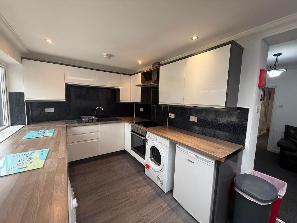 Modern fitted kitchen with wood-effect worktops...
