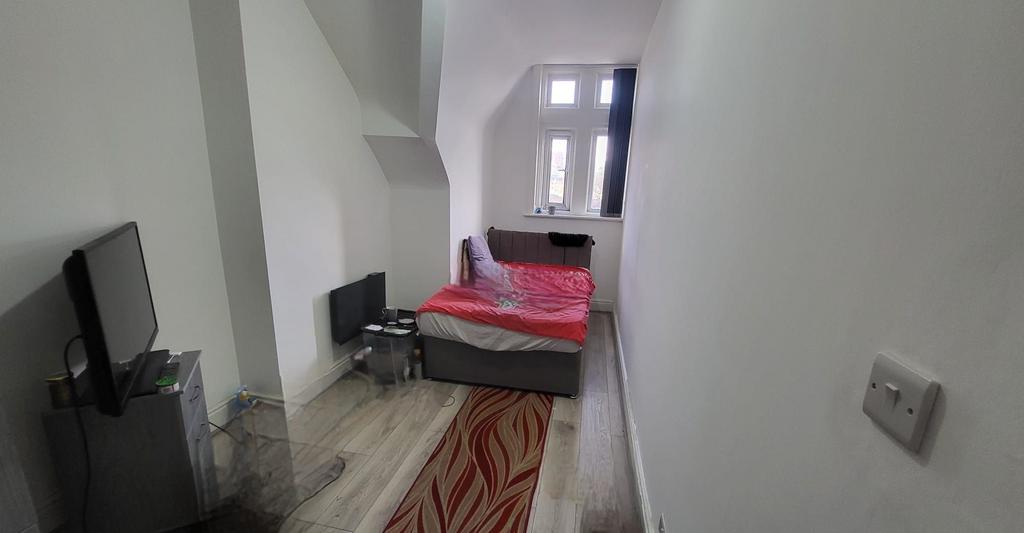 Long, narrow bedroom with a single bed by a bri...