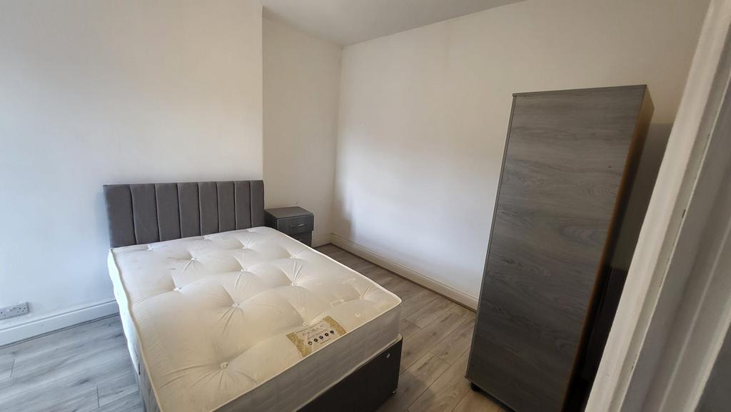 Bright, simply furnished bedroom with a comfort...