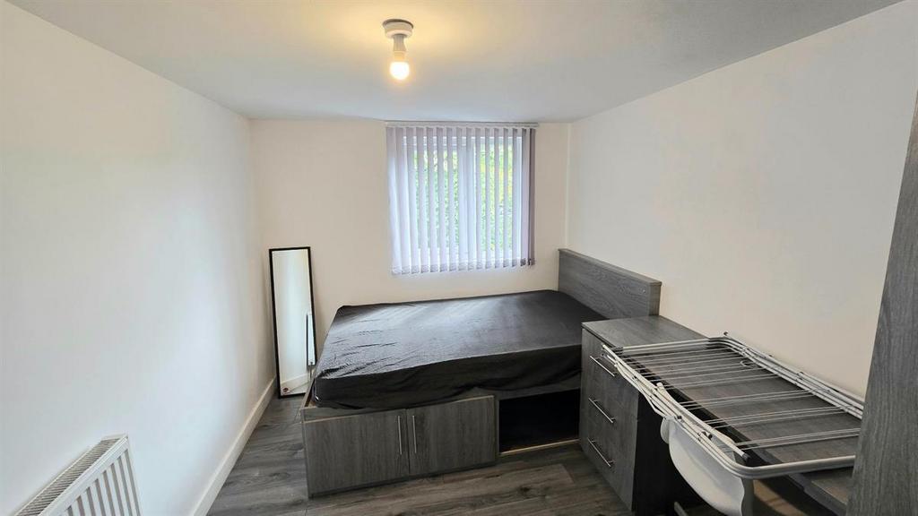 Neat single bedroom with a raised storage bed, ...