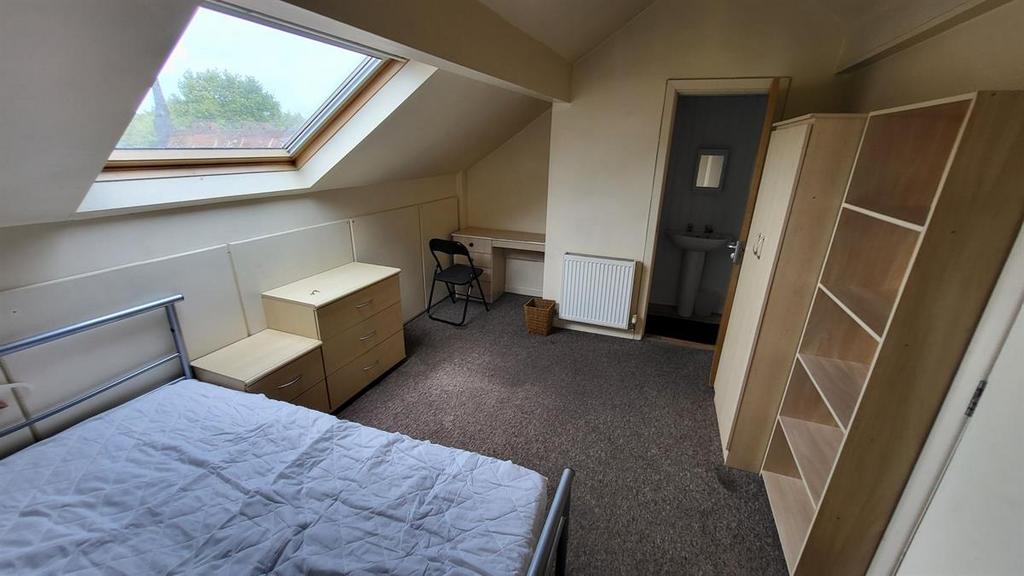 Bright attic bedroom with a large skylight, com...