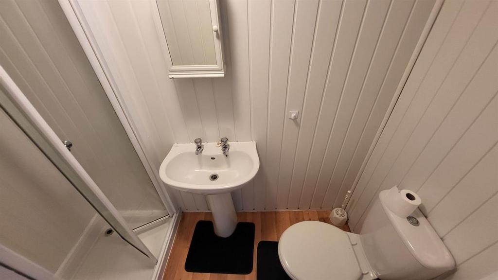 Compact, well-kept bathroom with a corner showe...