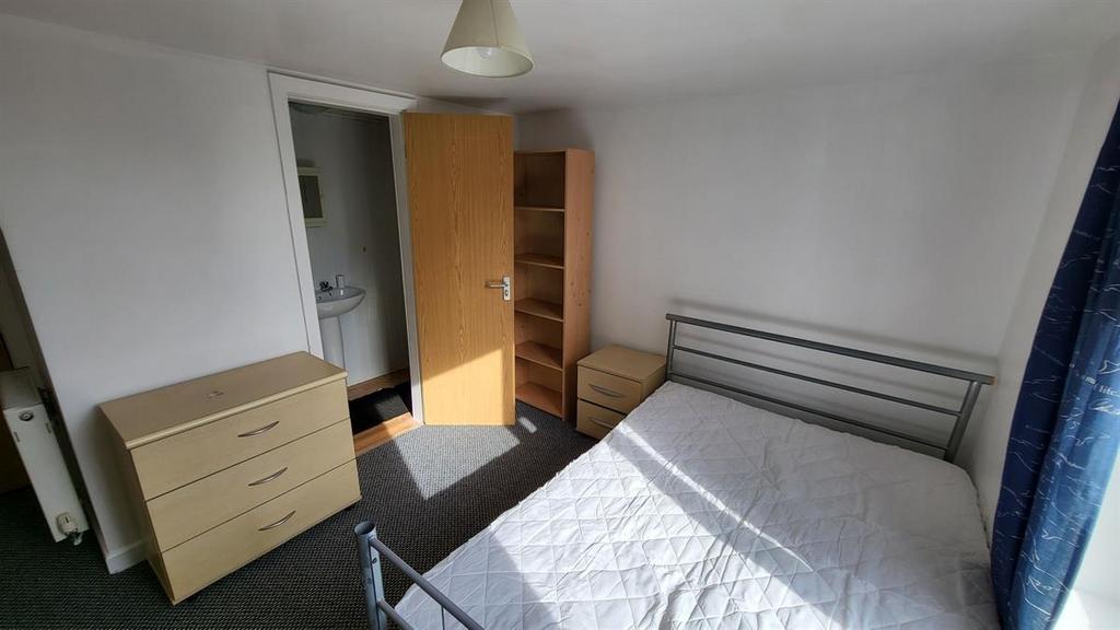 Bright double bedroom with a metal-frame bed, m...