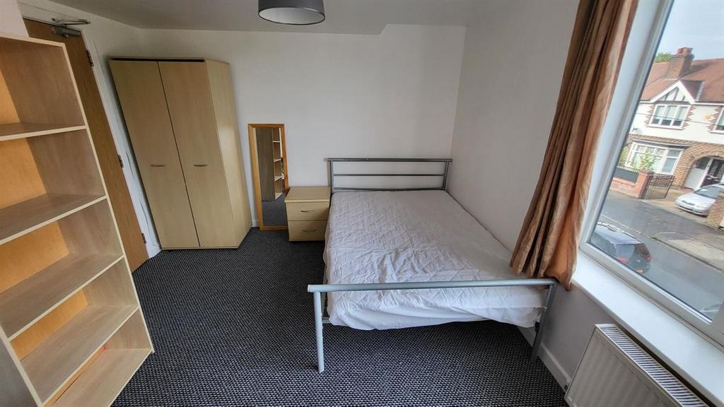 Bright, simply furnished bedroom with a window ...