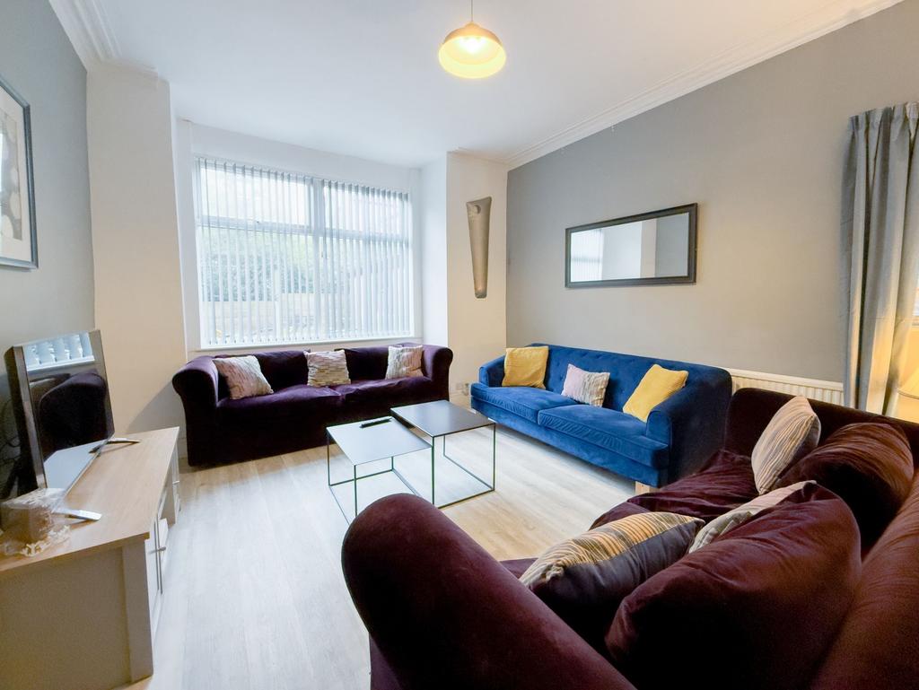 Bright, stylish living room with large front wi...