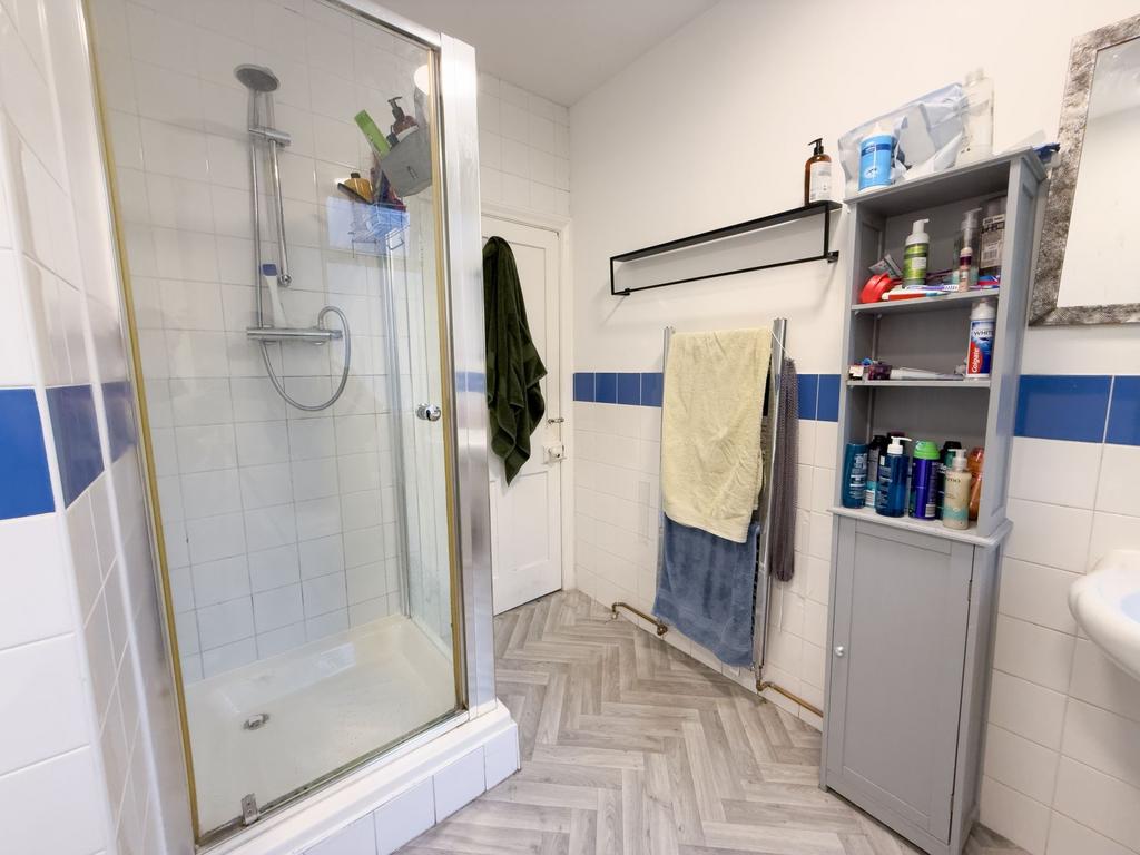 Bright tiled bathroom with a glass shower enclo...