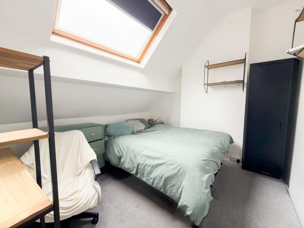 Bright attic double bedroom with a skylight, a ...