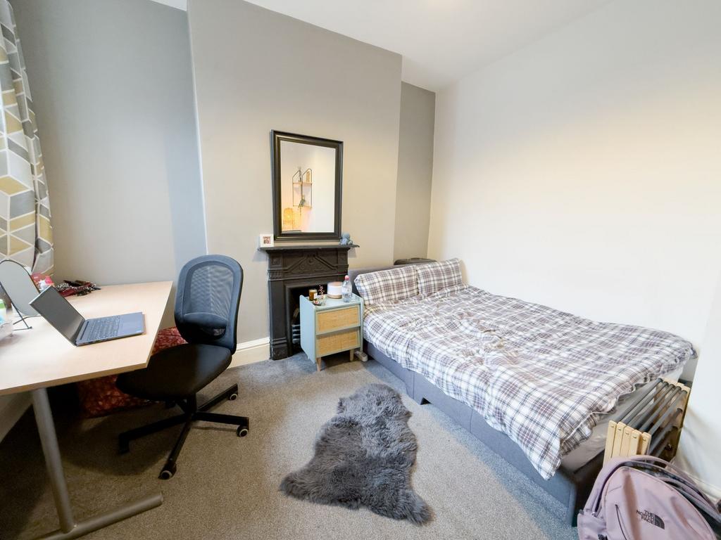 Bright, neatly furnished bedroom with a comfort...