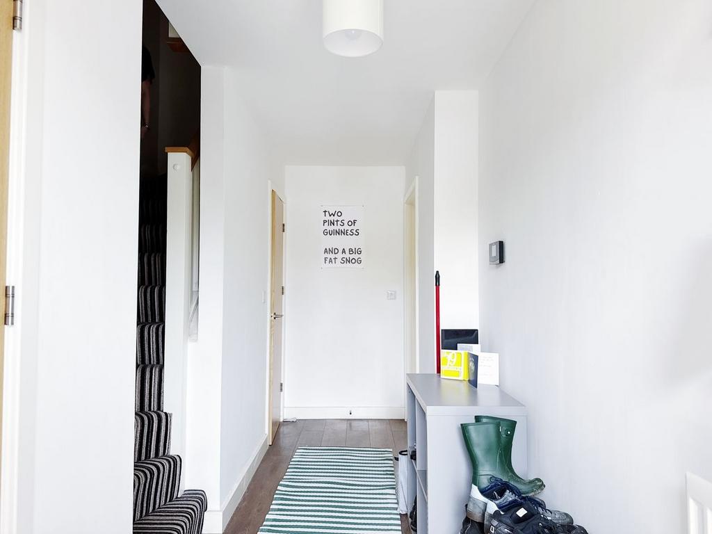 Bright, minimalist hallway with white walls, st...