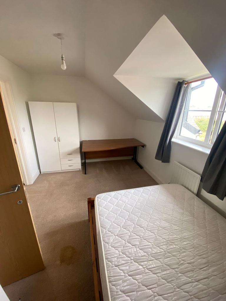 Bright double bedroom with a large window and a...