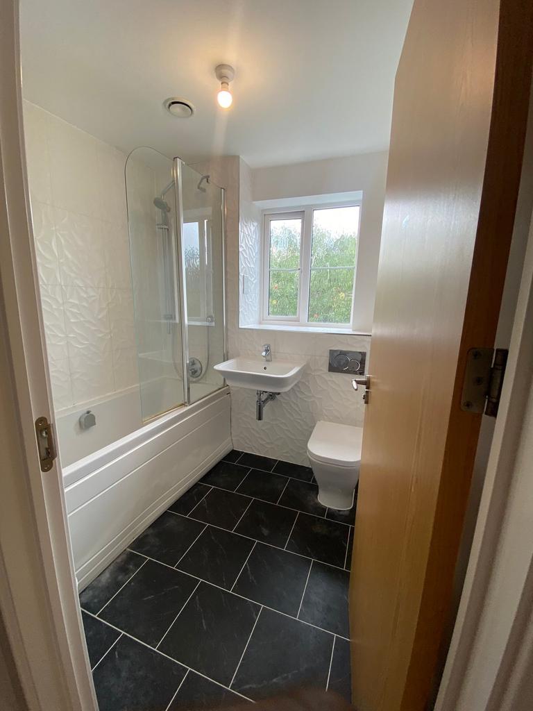 Bright, modern bathroom with a combined bath an...