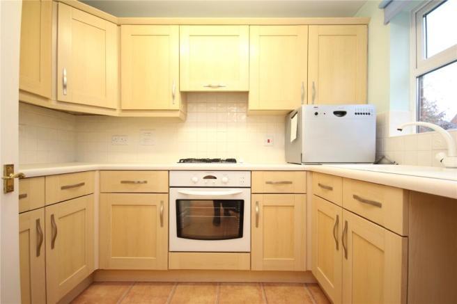 Bright, modern fitted kitchen with light wood c...